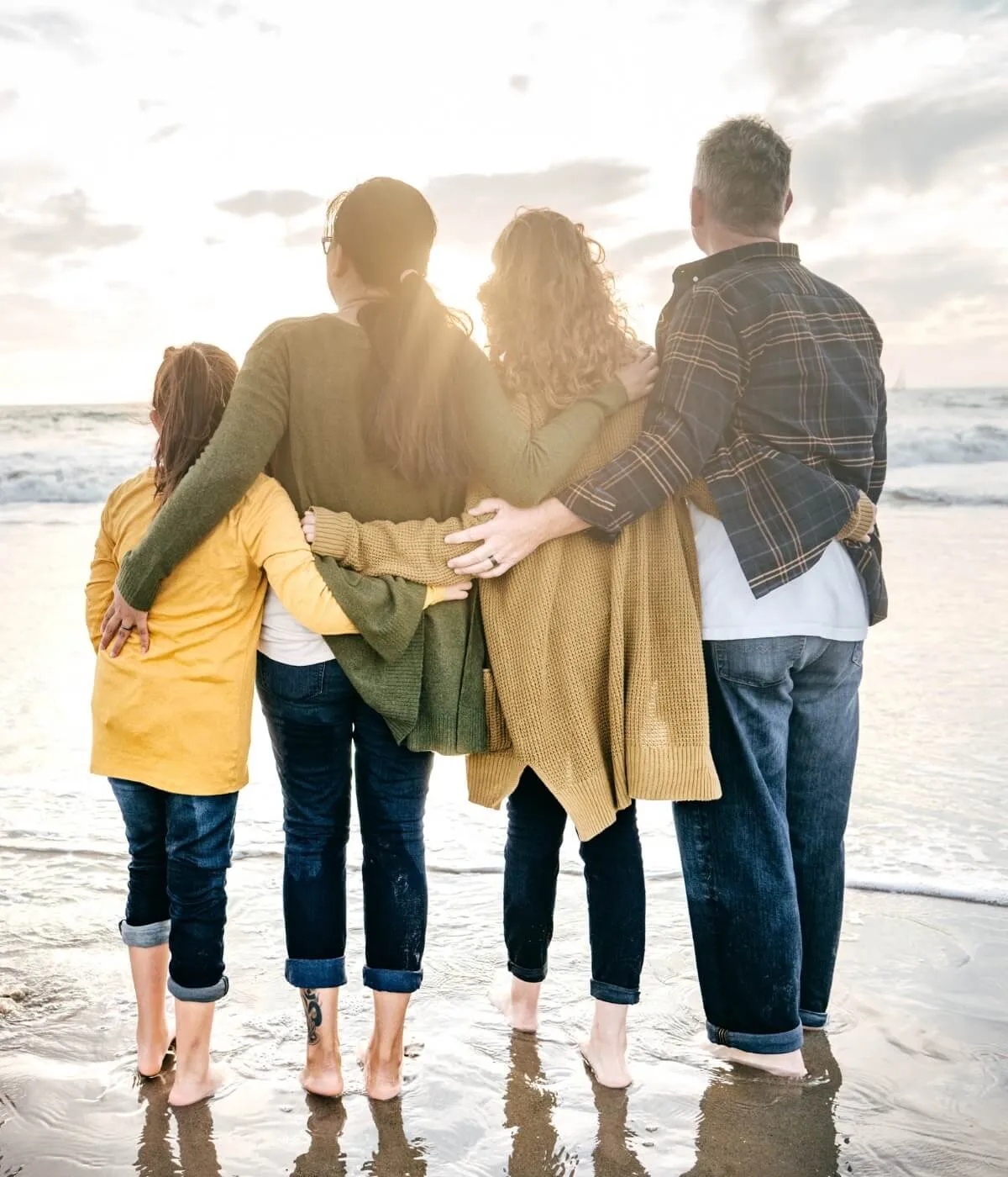 A family together on a beach at sunset, reassured their Will and Lasting Power of Attorney are in place